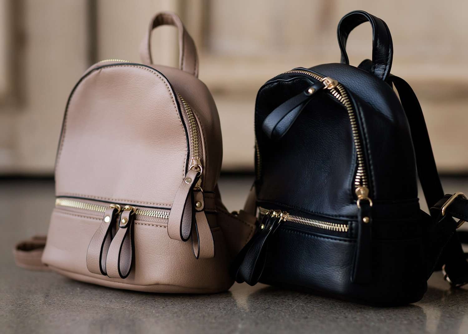 black or taupe small leather backpack purse.