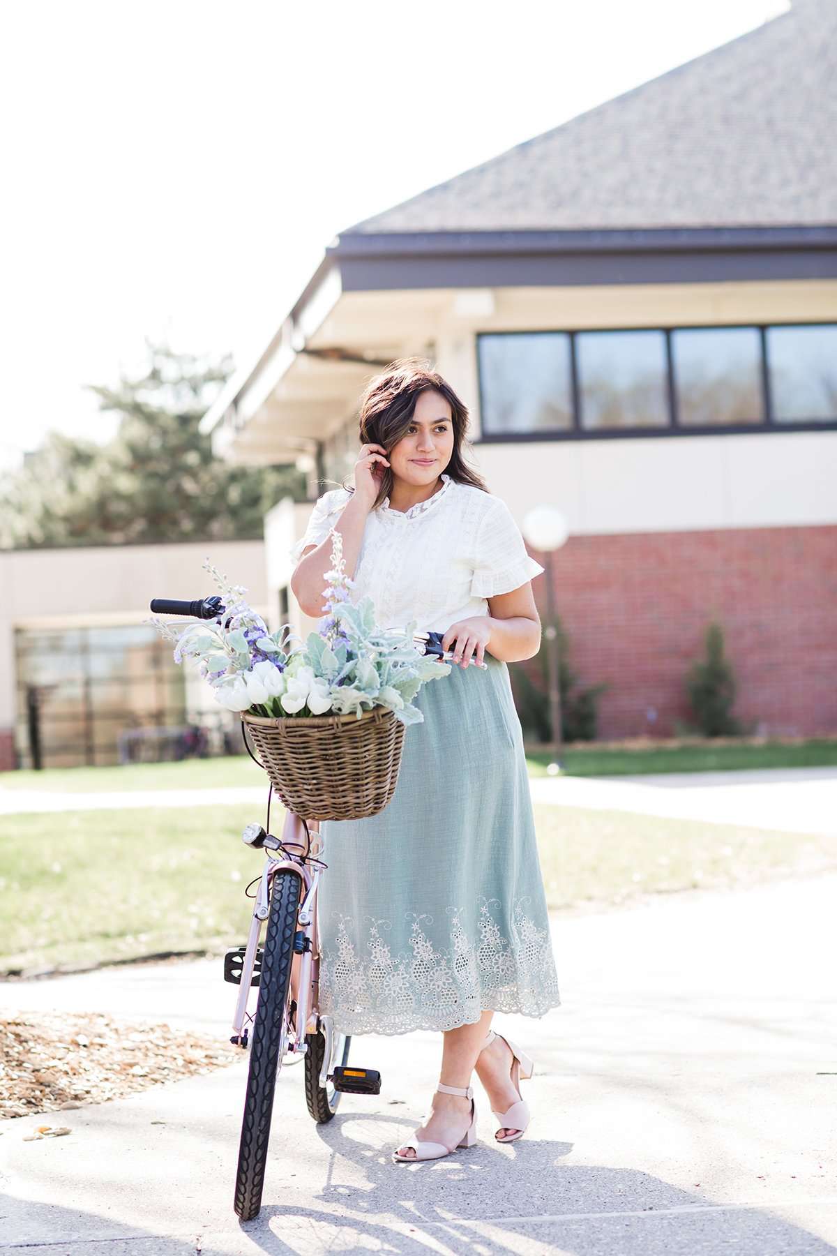 Woman wearing a mint green cotton midi skirt with a self tie and feminine crochet lace detail at the bottom hem