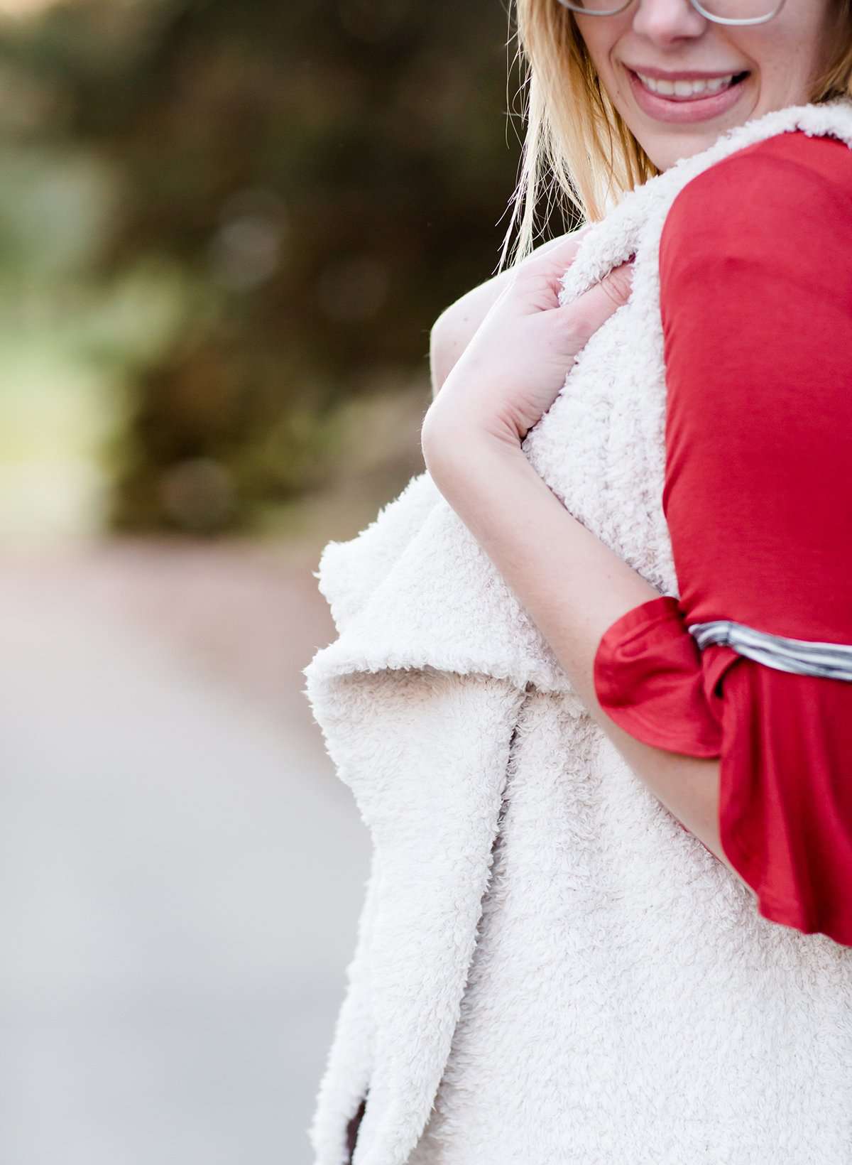 Young woman in a modest black midi skirt wearing a cream colored, soft drape style vest.