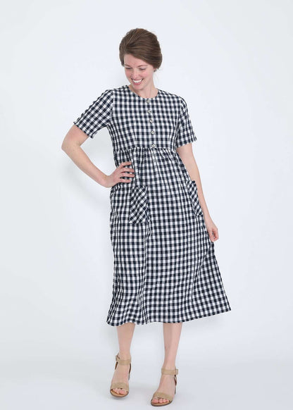 woman wearing a navy and white gingham print midi dress