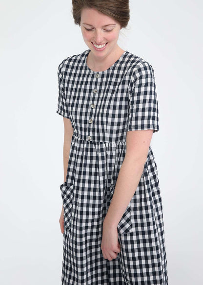 woman wearing a navy and white gingham print midi dress