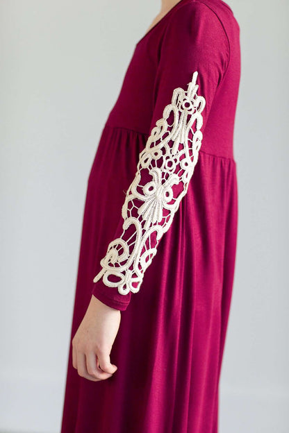 Young girl wearing a burgandy maxi dress with crochet detail.