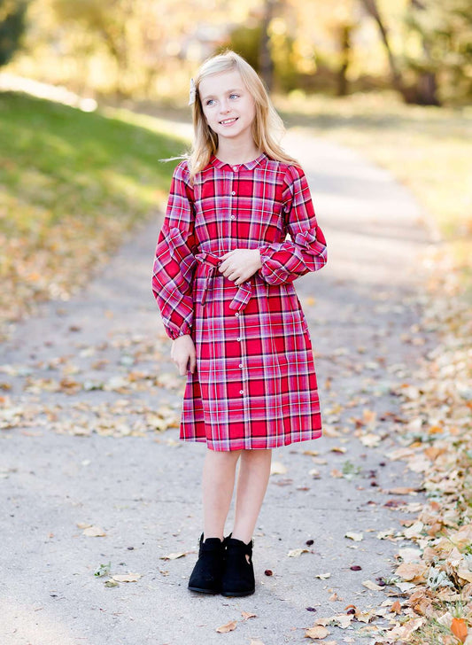 Young girl wearing a modest red plaid midi dress with balloon style sleeves. This dress also features a self tie fabric waist and is lined.